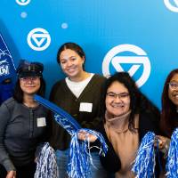 Mentees and mentors taking photos at the booth with GVSU props